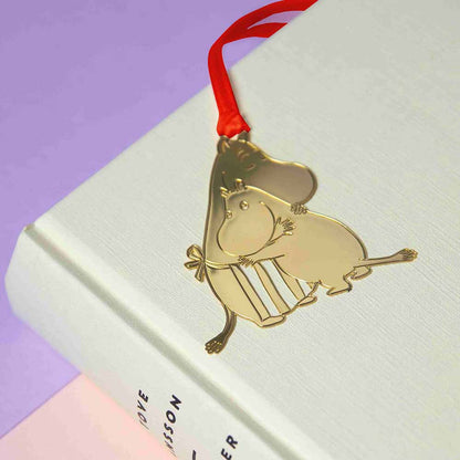 Gold Moomin Love bookmark hanging from a book