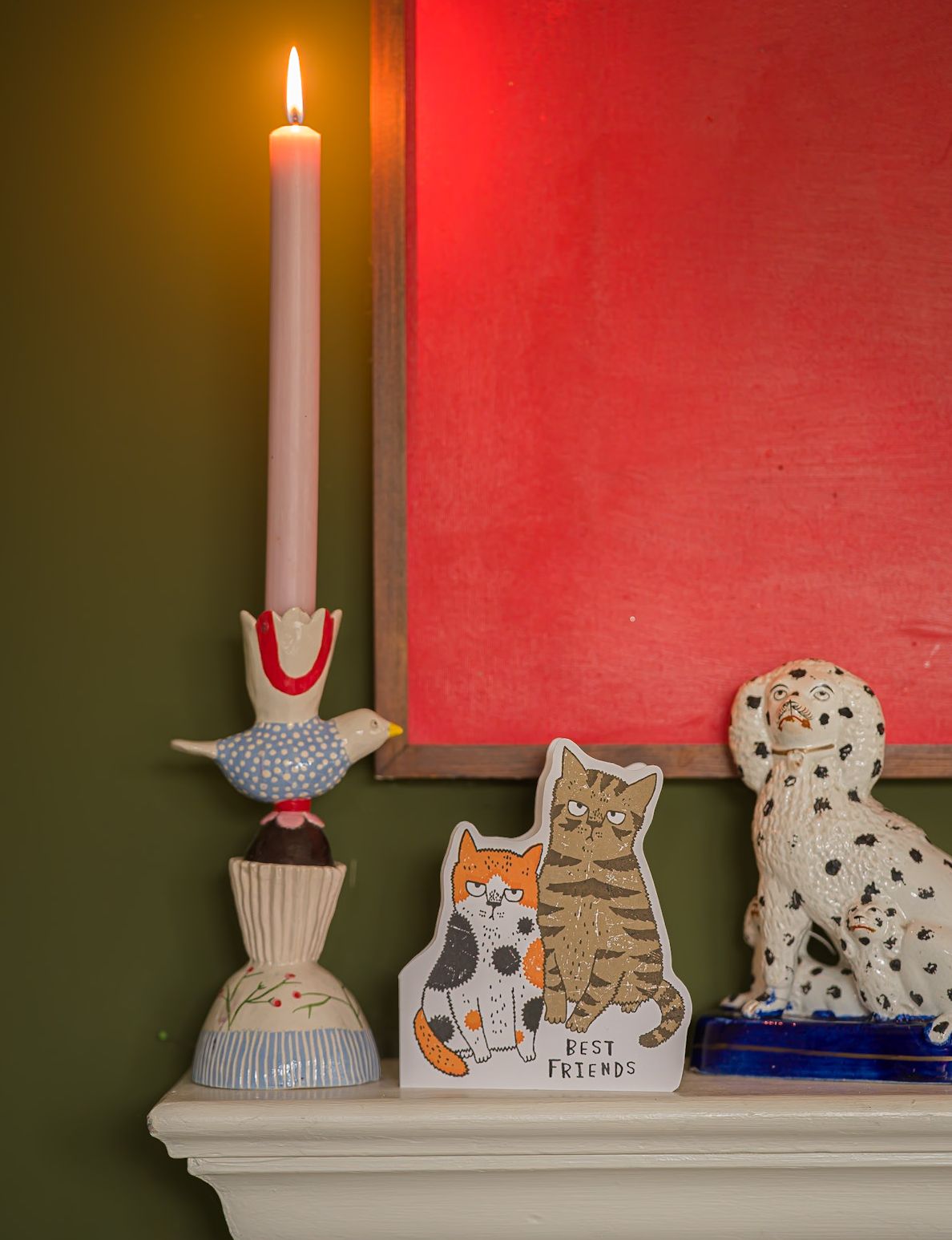 The cat card standing on a mantelpiece beside a candle and a china dog