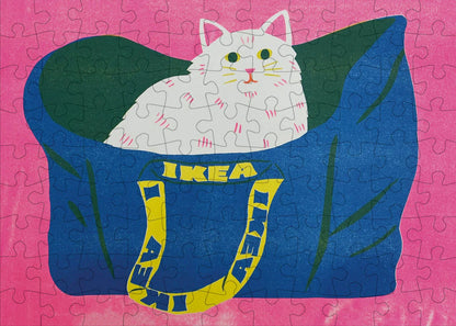 Completed jigsaw of a white cat peeking out of a big blue IKEA bag