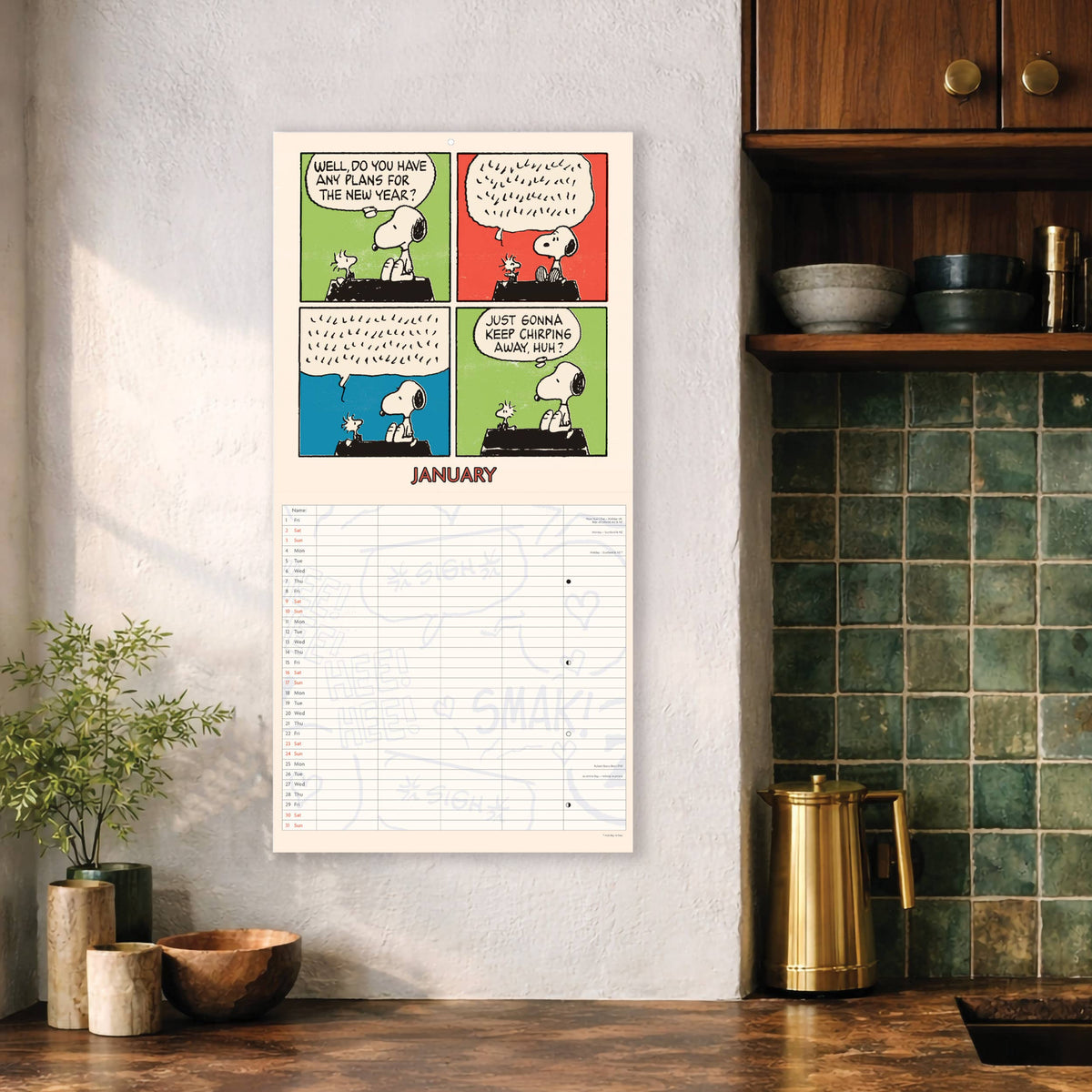 Peanuts family calendar hanging on a kitchen wall