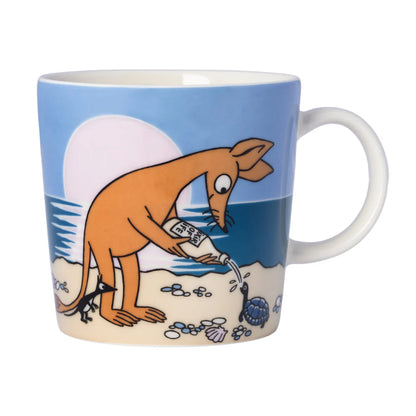 Moomin Sniff mug: Sniff gathering treasure on the beach under a pale sun