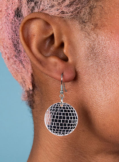 Disco ball earring worn on a person with pink hair