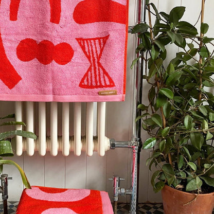 Pink and red abstract towels hanging on a radiator