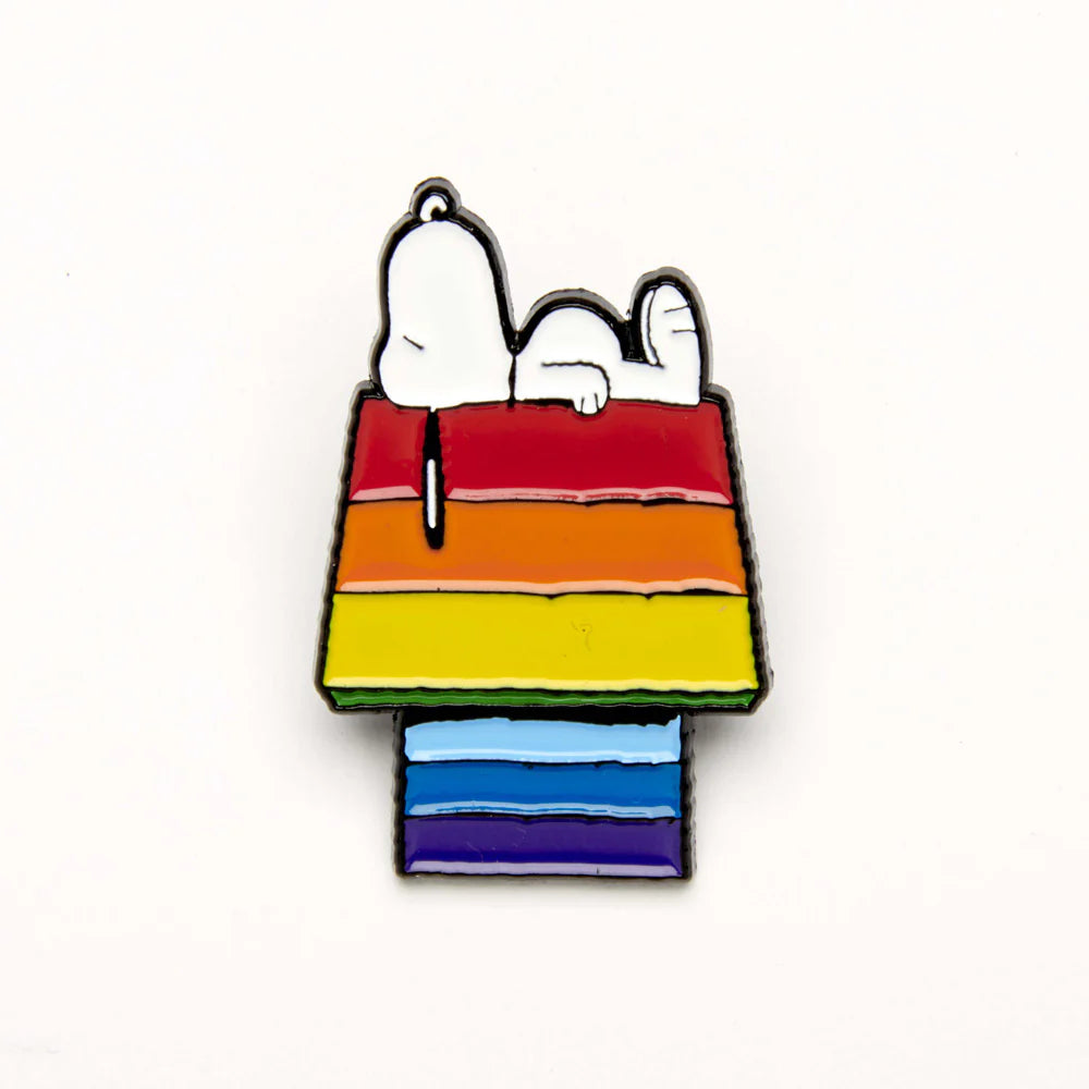 Enamel pin of Snoopy asleep on a rainbow-striped kennel