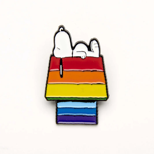 Enamel pin of Snoopy asleep on a rainbow-striped kennel