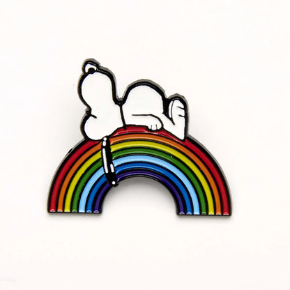 Enamel pin of Snoopy lying on a rainbow