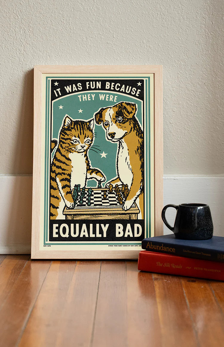 Equally Bad print in a frame on a wooden floor