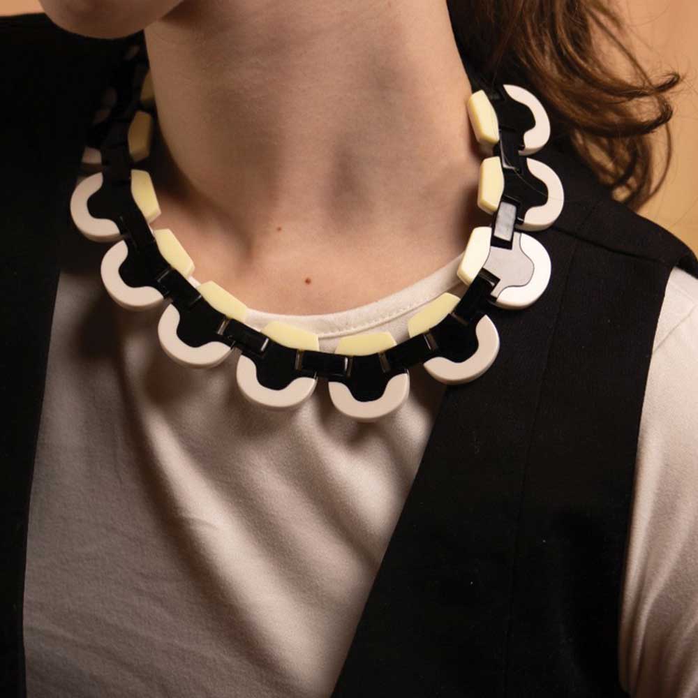 Woman wearing a black and cream wave-edged acrylic necklace