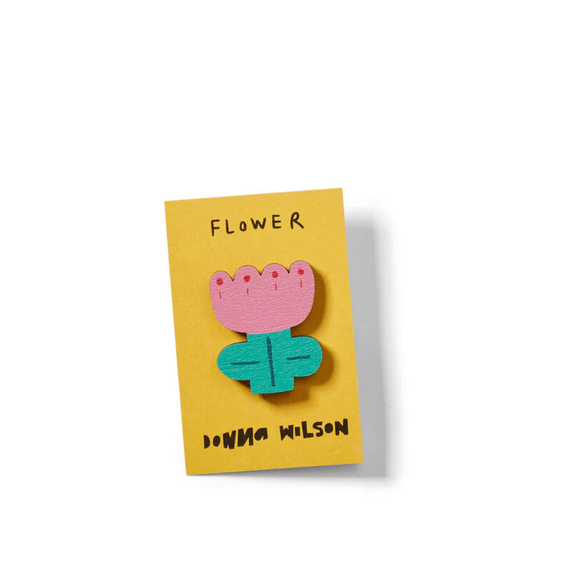 Donna Wilson flower pin badge: a pink and teal wooden flower on its yellow card