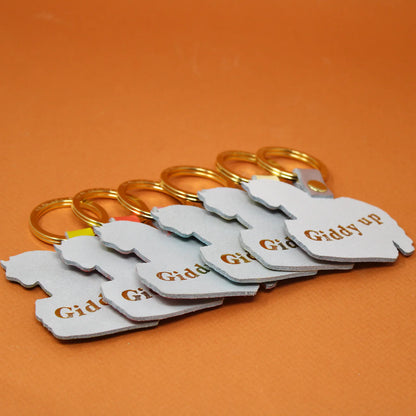 Row of grey leather key fobs with gold rings, stamped Giddy up