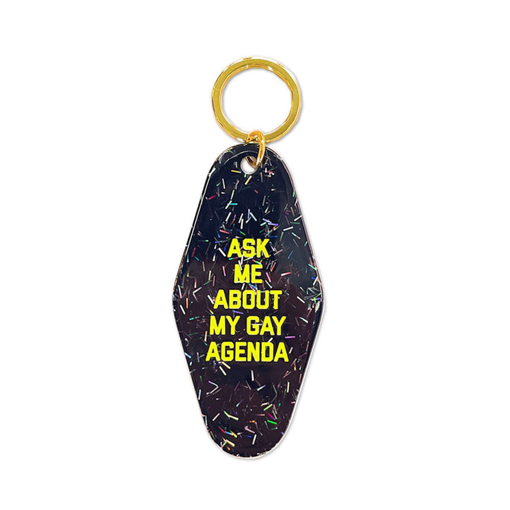 Navy glitter motel-style key tag in yellow lettering: Ask me about my gay agenda