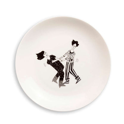 White plate with a black line drawing of a couple dancing