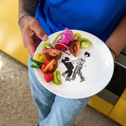 Person holding the dancefloor plate topped with a salad