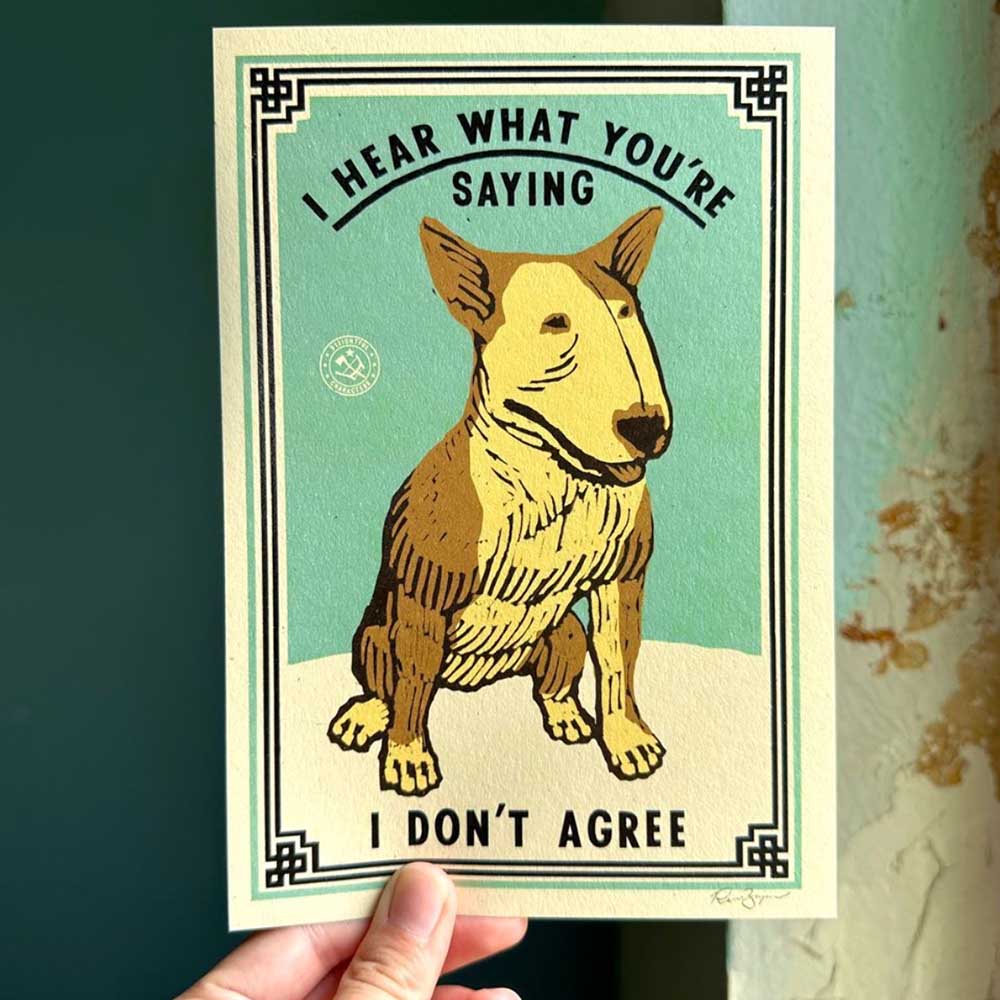 Hand holding a print of a bull terrier: I hear what you're saying, I don't agree