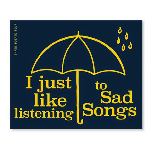 Three Potato Four sticker: a yellow umbrella and raindrops on navy, with 'I just like listening to sad songs'