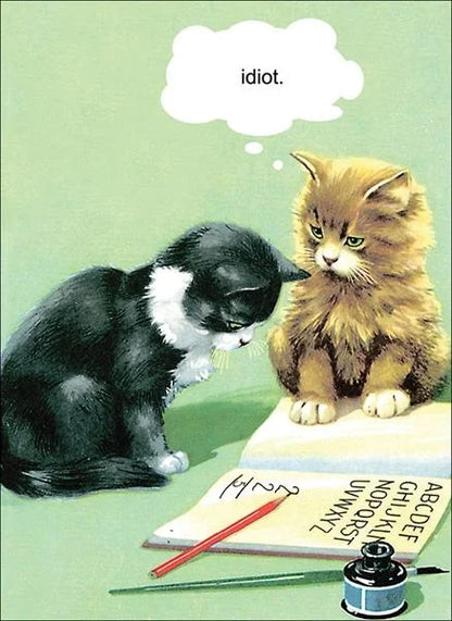 Kiss Me Kwik card: a black and white kitten and a ginger kitten over a spelling book, with a thought bubble saying 'idiot.'