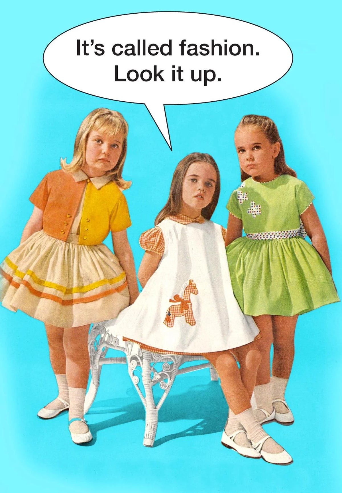 Kiss Me Kwik card: three 1960s girls in dresses, one saying 'It's called fashion. Look it up.'