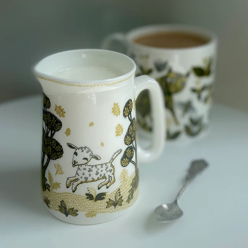 Lamb jug of milk beside a mug of tea