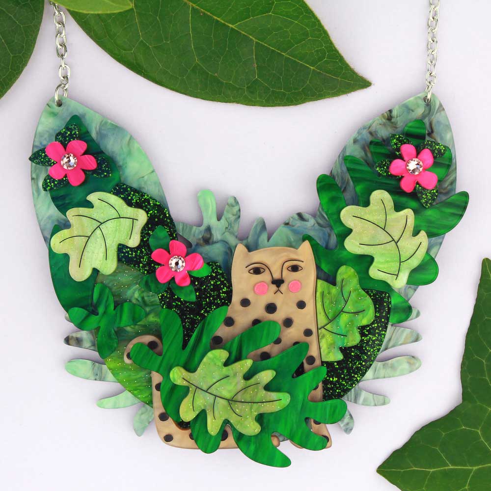 Acrylic statement necklace with a leopard hiding among green jungle leaves and pink flowers