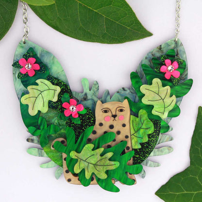 Acrylic statement necklace with a leopard hiding among green jungle leaves and pink flowers