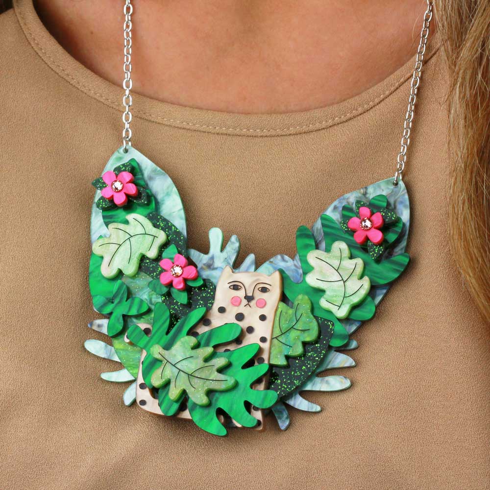 Close-up of the leopard statement necklace worn over a beige top