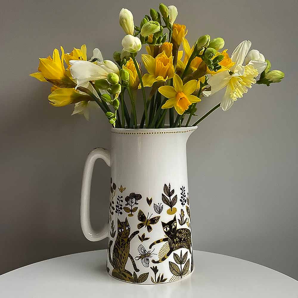 Lush Designs yellow cat jug holding daffodils