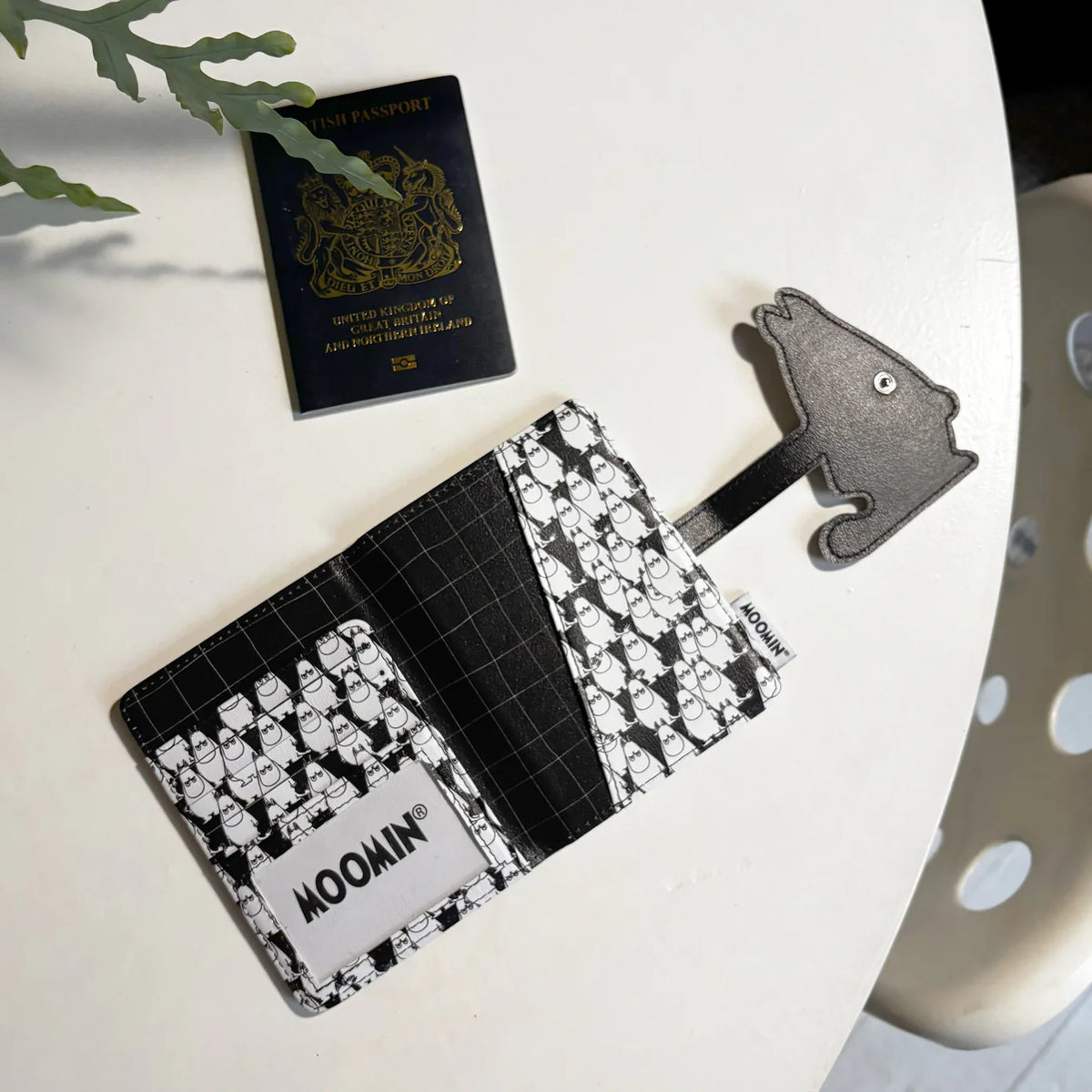 Moomin passport holder opened, with a Moomintroll-shaped clasp