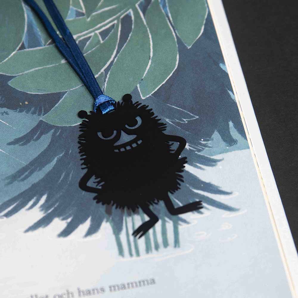 Stinky bookmark hanging on a ribbon over a book page