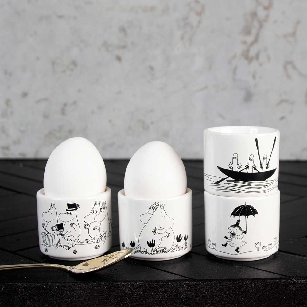 Moomin egg cups with eggs, illustrated in black and white