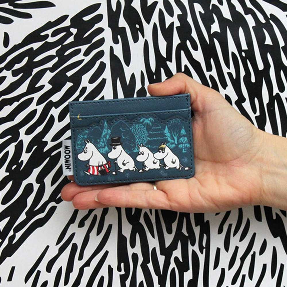 Hand holding the teal Moomin Forest card holder with Moomins walking among trees