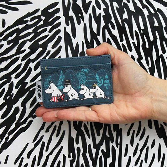 Hand holding the teal Moomin Forest card holder with Moomins walking among trees