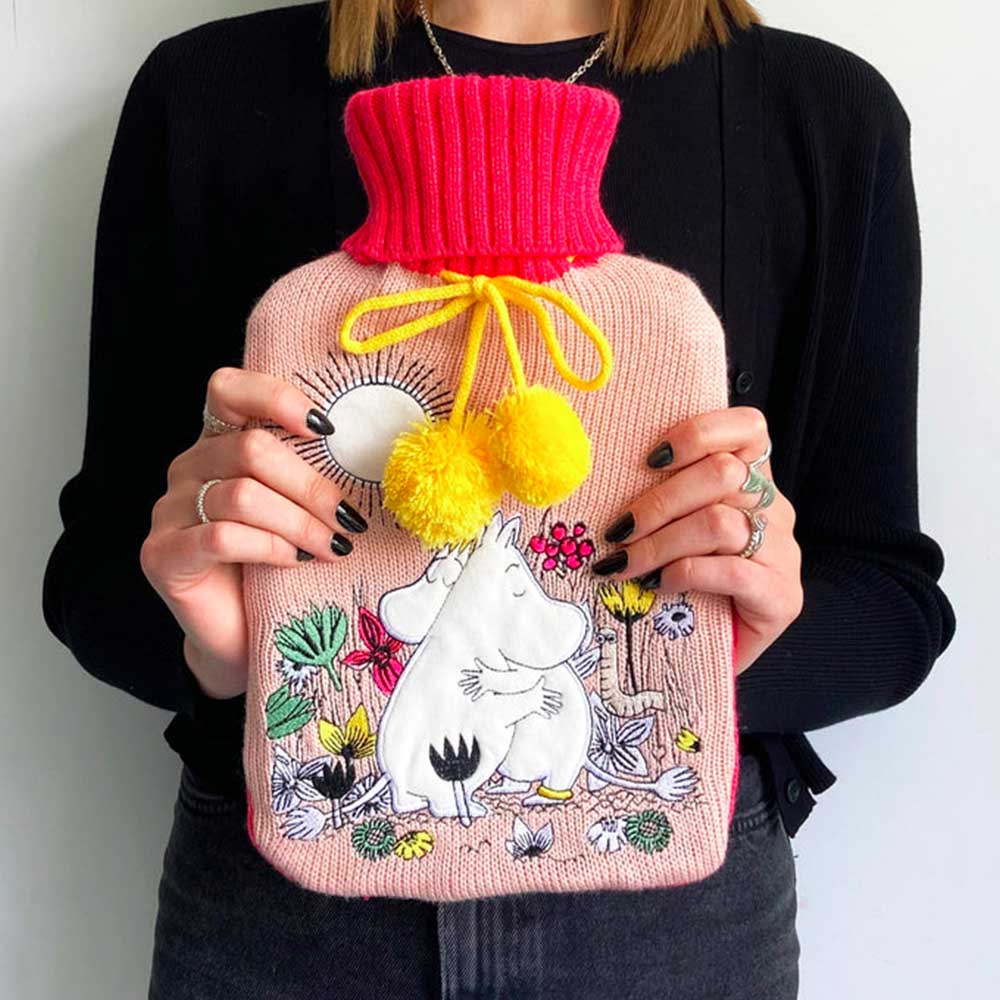 Person holding the pink Moomin Love hot water bottle