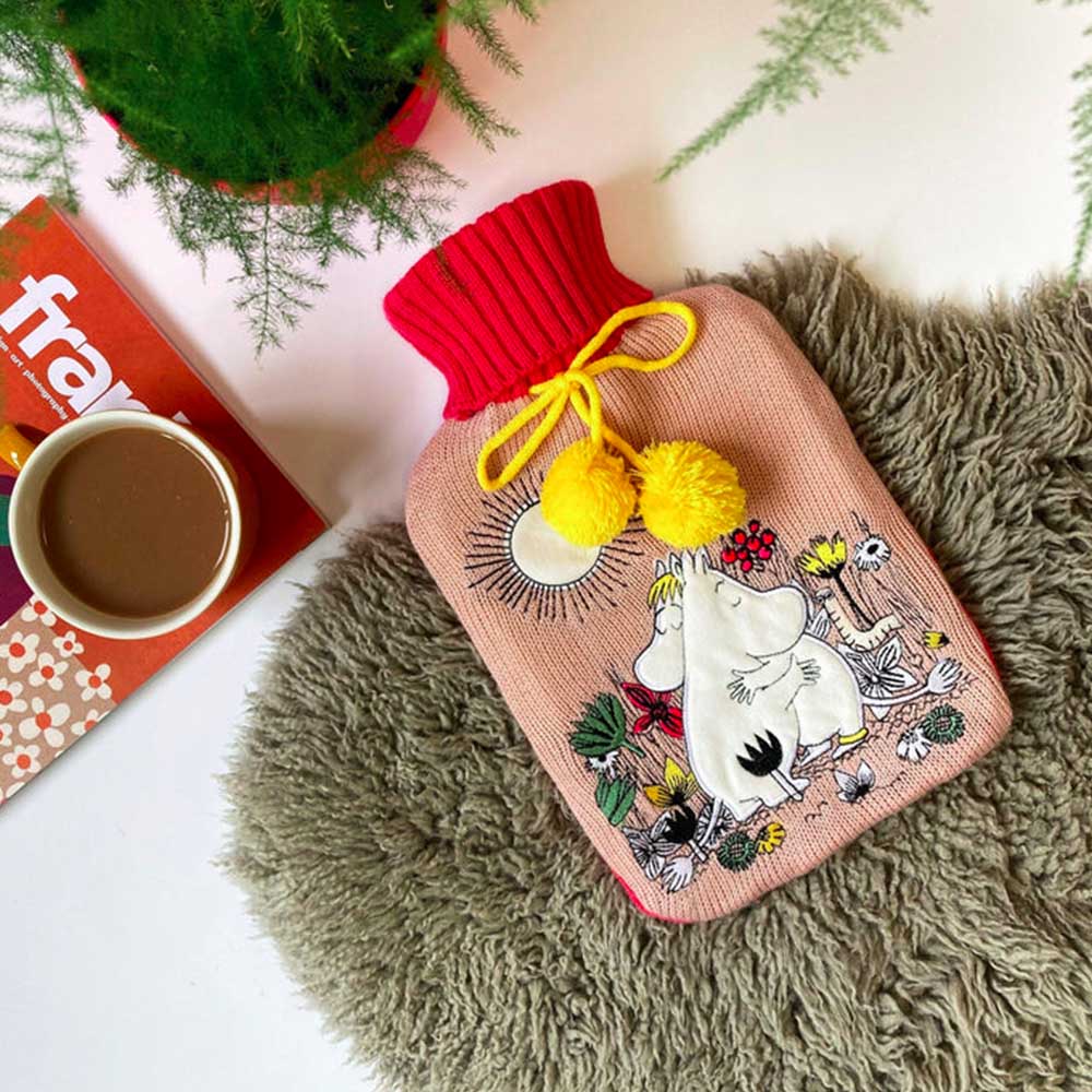 Moomin Love hot water bottle on a sheepskin with a coffee