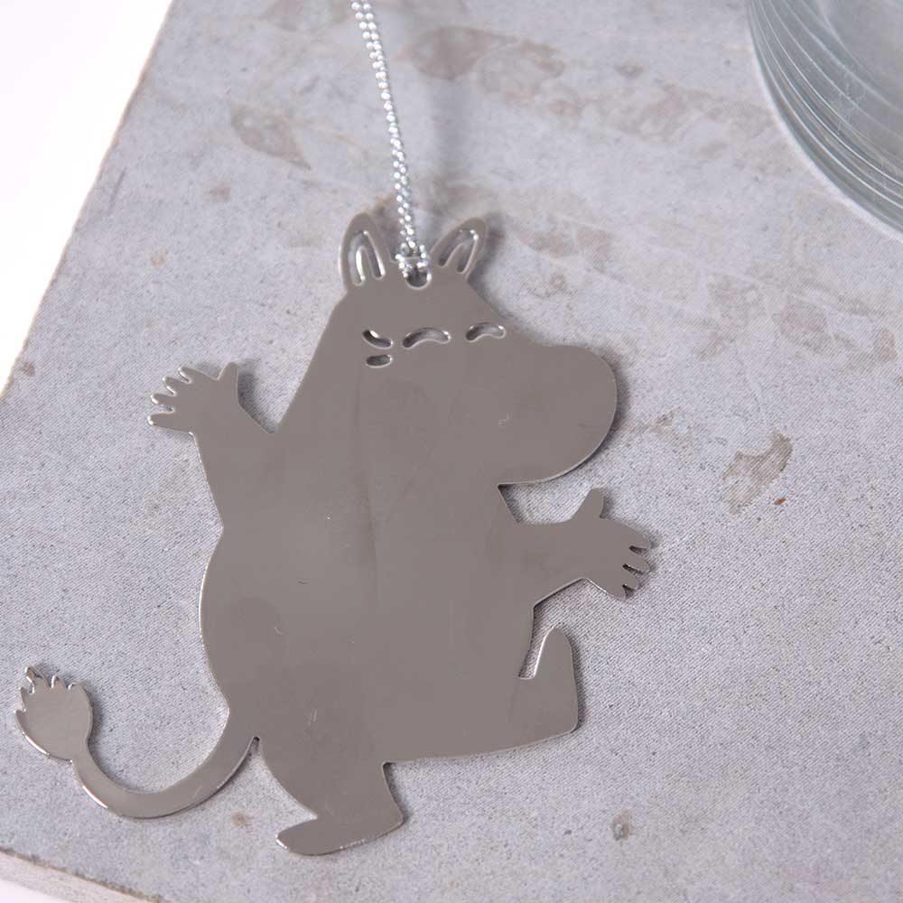 Silver Moomintroll decoration on a stone surface