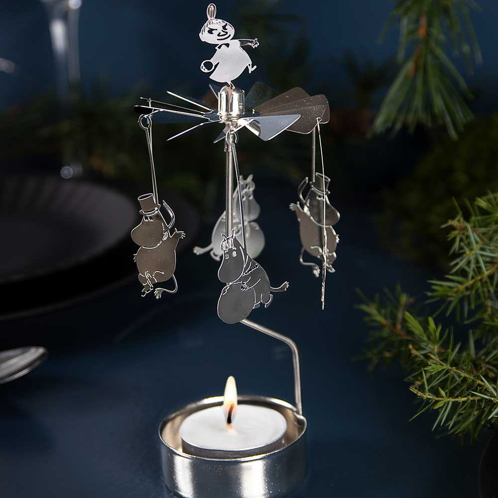 Moomin winter angel chime lit by a tealight among pine branches