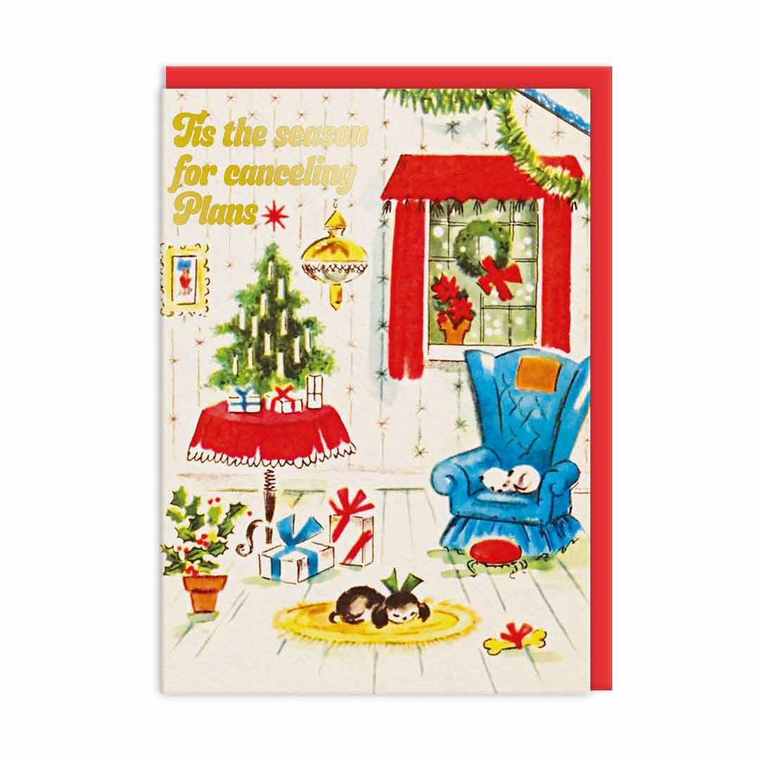 Ohh Deer Christmas card: a cosy room with a tree and armchair, with gold 'Tis the season for cancelling plans'
