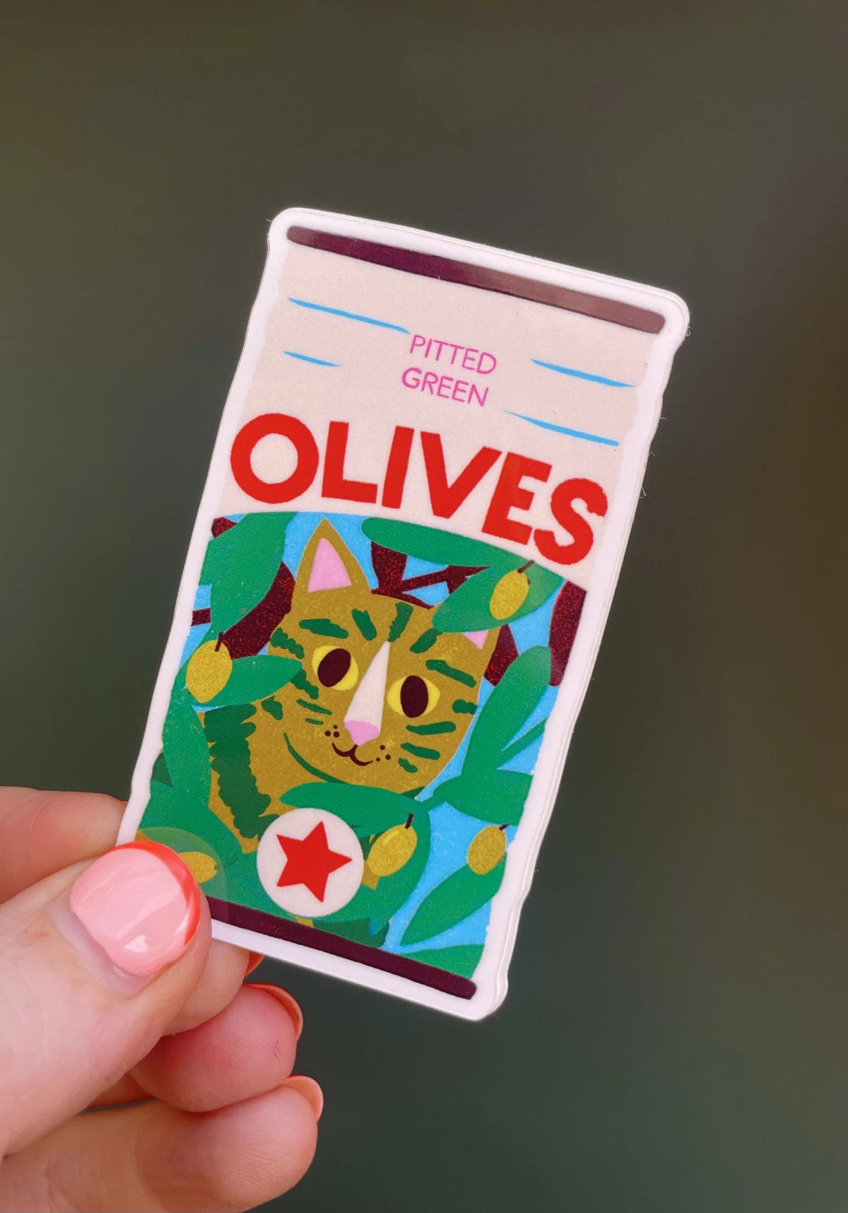 Naomi Wilkinson sticker: a jar of pitted green olives with a tabby cat on the label, held in a hand