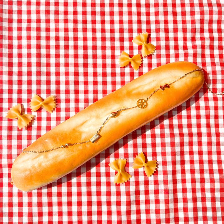 Pasta shape necklace draped over a baguette