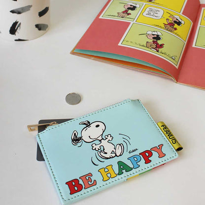 Peanuts 'Be happy' purse with dancing Snoopy beside a comic book