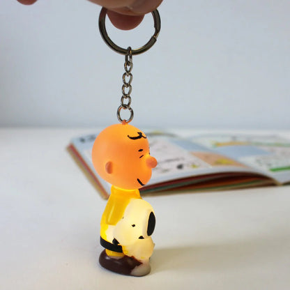 Charlie Brown and Snoopy key ring held up in front of a comic book