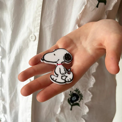 Hand holding the Snoopy brooch