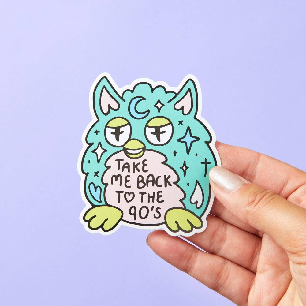Hand holding a teal Furby-style sticker: Take me back to the 90's