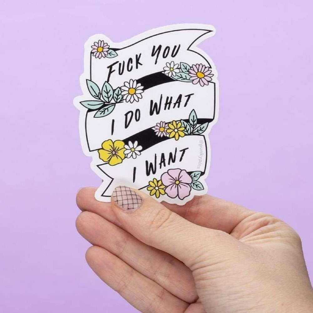 Hand holding a floral banner sticker: Fuck you I do what I want