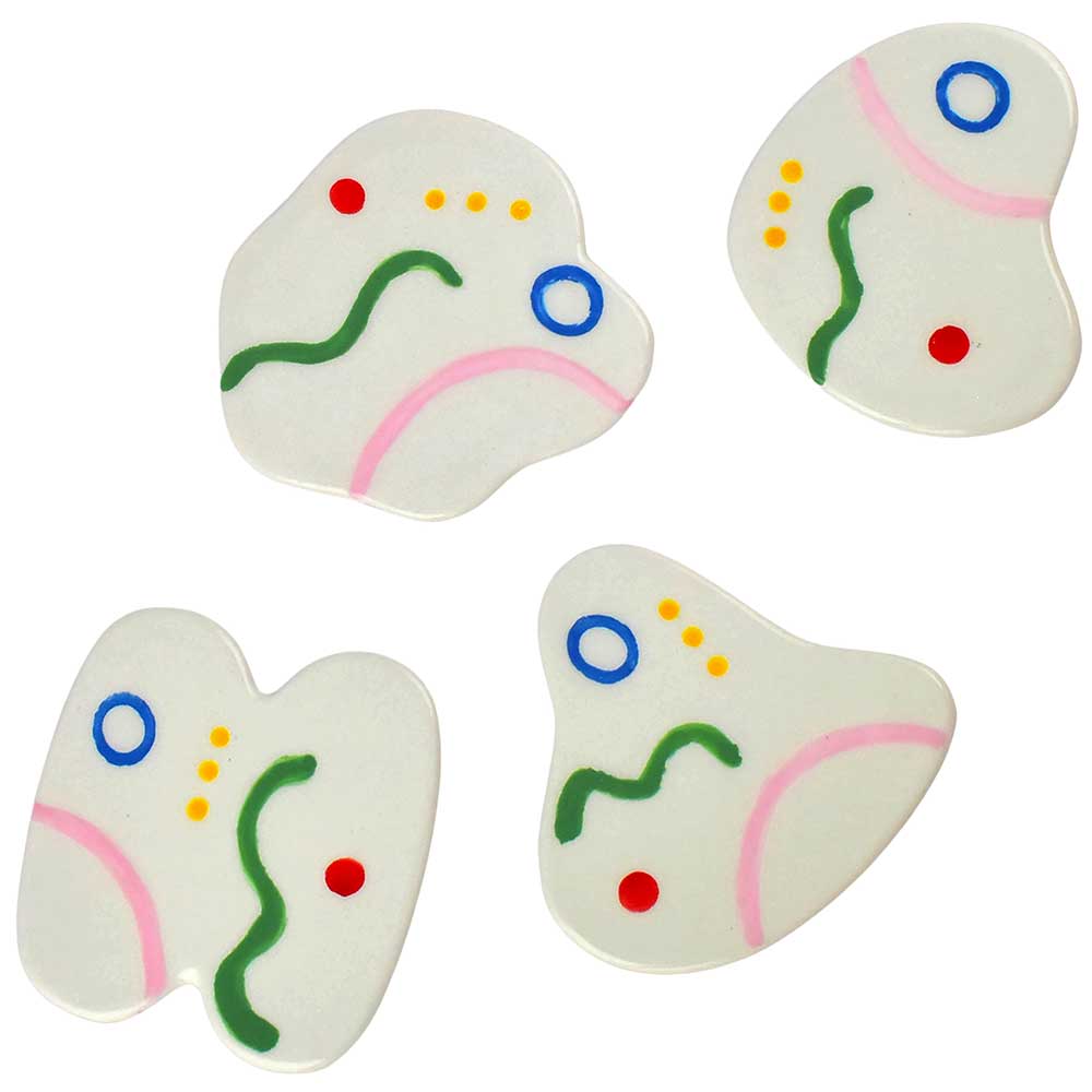 Que Rico Belen coasters: organic-shaped white coasters with painted squiggles in green, pink, blue and yellow