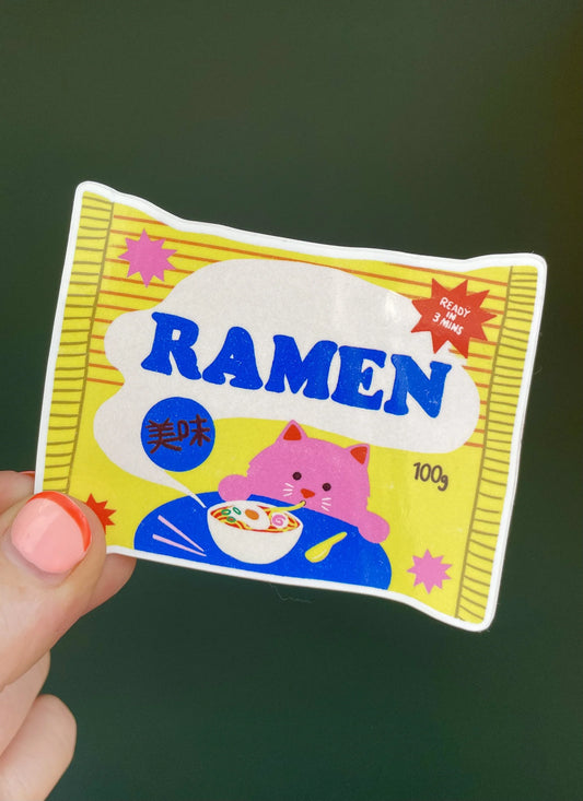 Naomi Wilkinson sticker: a packet of ramen with a pink cat eating noodles, held in a hand