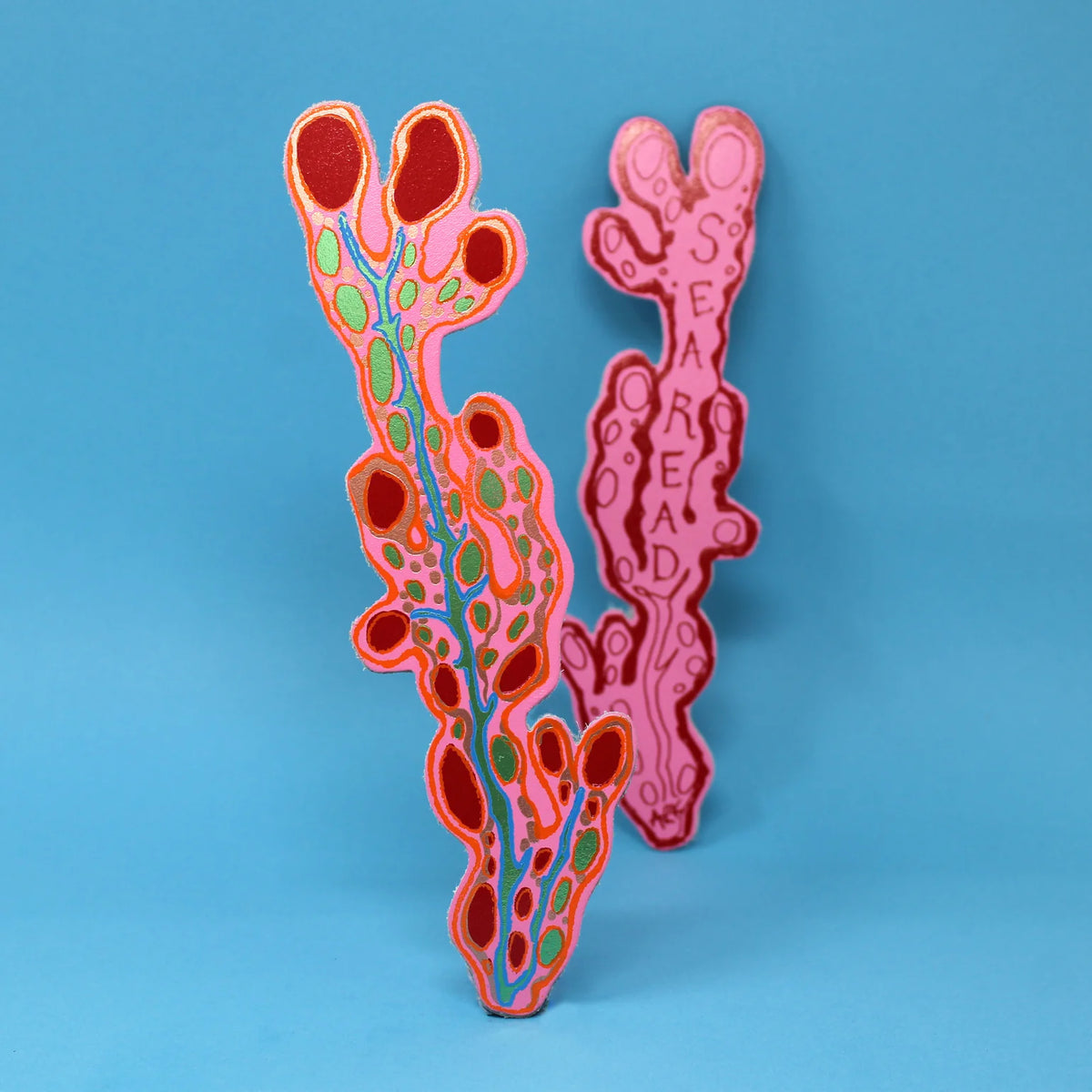 Ark pink seaweed bookmark with red and green details, on blue