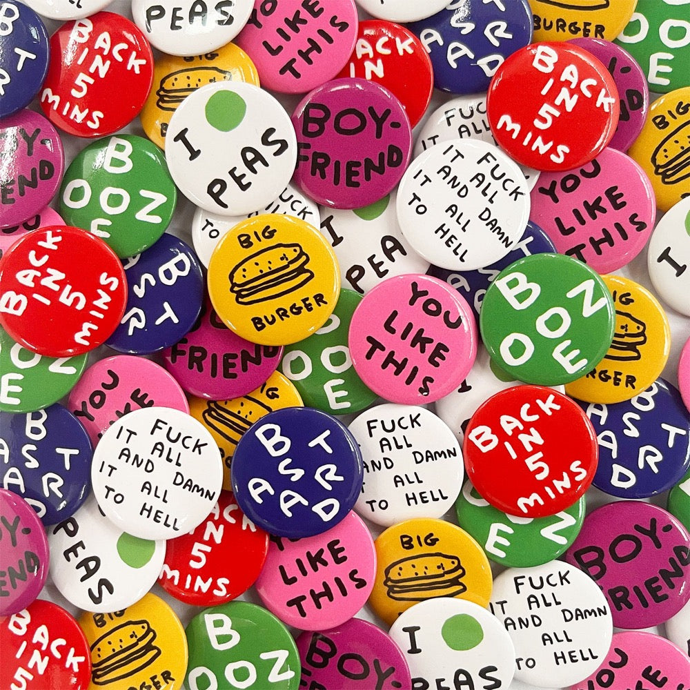 A pile of colourful David Shrigley badges