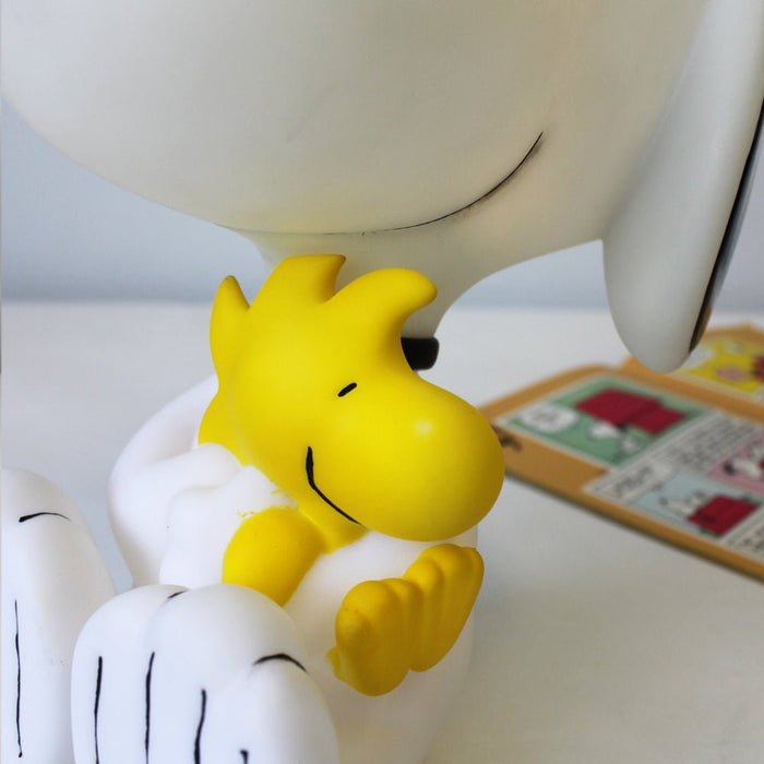 Close-up of yellow Woodstock in Snoopy's arms