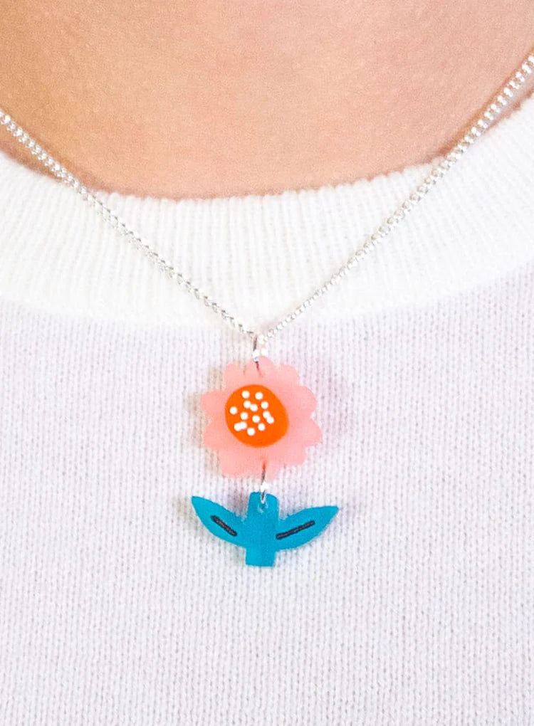 Springtime flower pendant worn with a white jumper