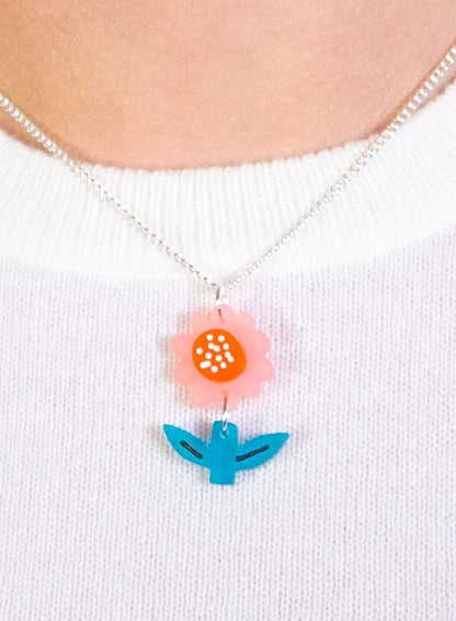 Springtime flower pendant worn with a white jumper